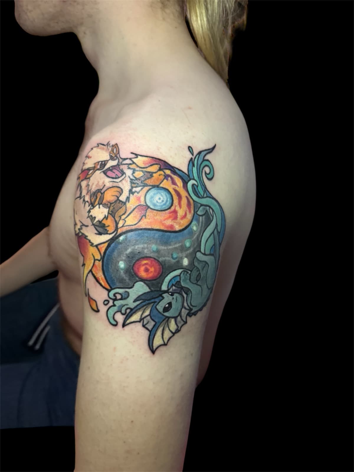 Pokémon yin-yang tattoo on shoulder — Arcanine and fire on top, Vaporeon and water below, fire and water meeting in the middle.
