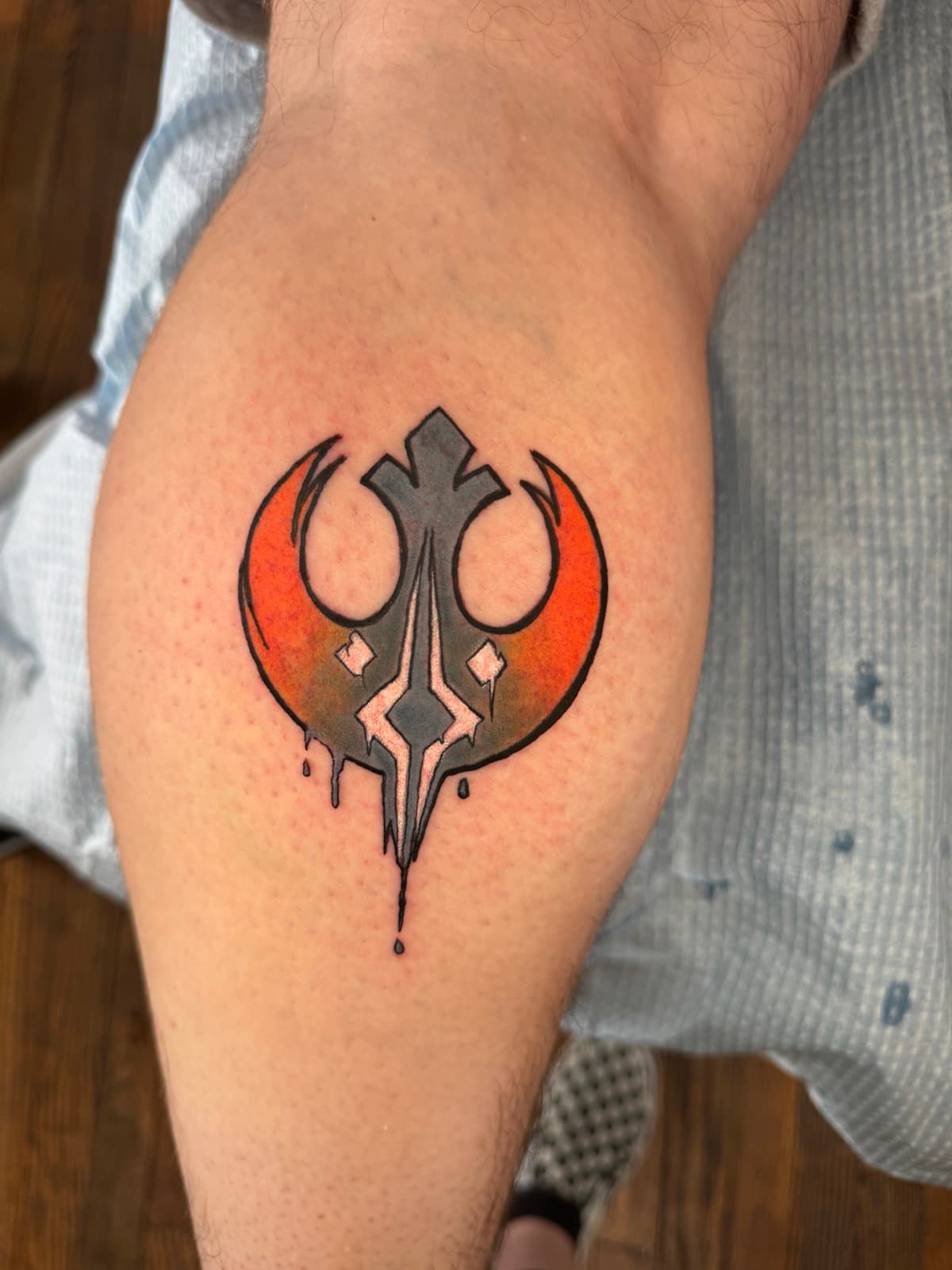 Star Wars calf tattoo combining the Rebel Alliance starbird and the Jedi Order crest, with orange-to-grey gradient and paint drips.