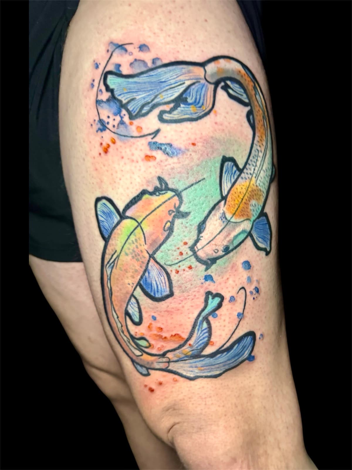 Watercolor koi fish pair tattoo — two orange and yellow koi with blue fins swimming in a yin-yang formation with blue and orange watercolor splash background.